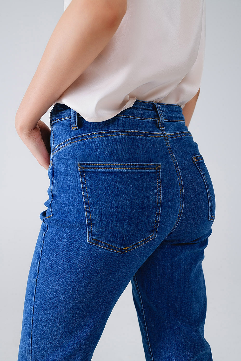 Jeans básicos de mezclilla azul oscuro con detalle de trenza en la cintura