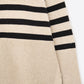 Beige oversized turtleneck sweater with black stripes and splits on the side