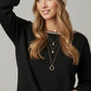 black fine knit sweater with a boat neck and rhinestone detail