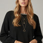 black fine knit sweater with a boat neck and rhinestone detail