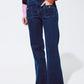 Blue jeans with buttoned pocket details in dark wash