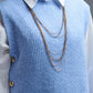 Blue sleeveless sweater with gold buttons on side