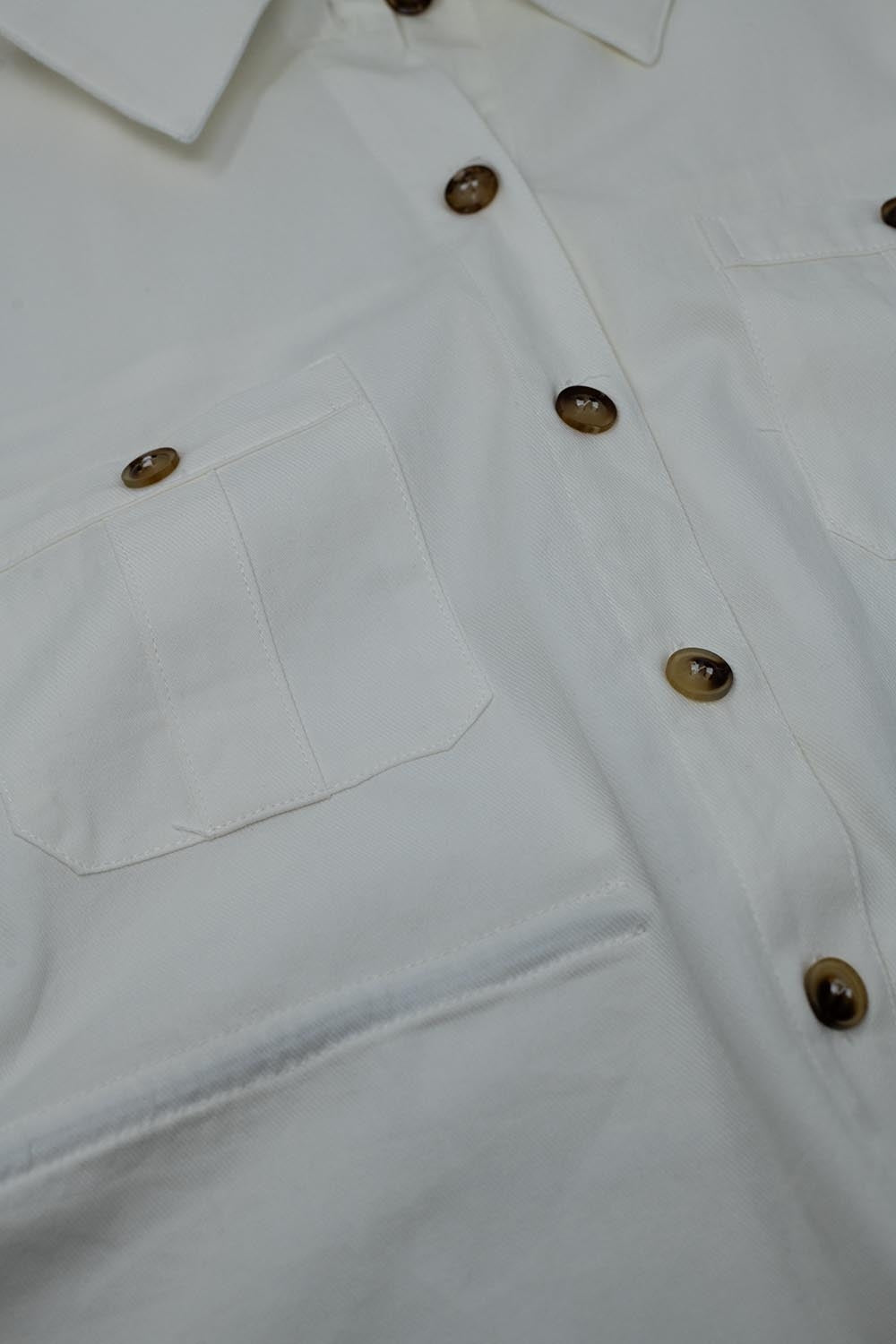 Camisa blanca con botones y bolsillos en el pecho