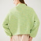 Fluffy light green sweater with high neck and balloon sleeves