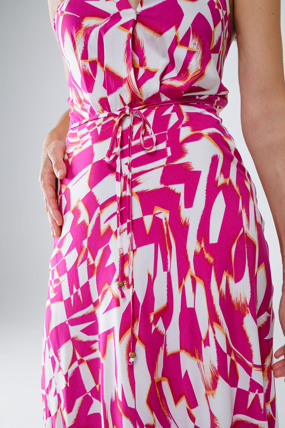 Vestido midi con cuello halter y cintura ceñida en estampado abstracto fucsia y blanco