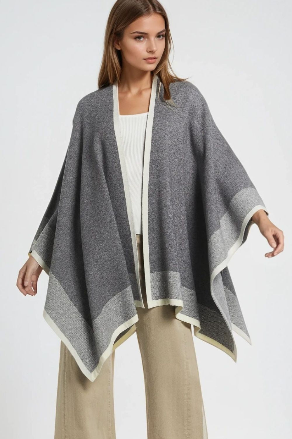 Q2 Knitted poncho in grey with ecru trim