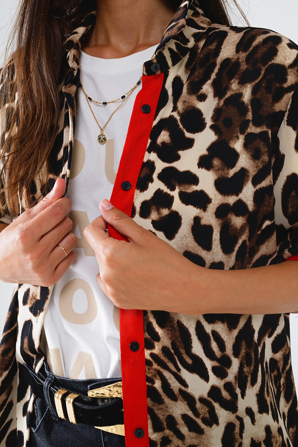 Camisa de leopardo con tapeta de botones rojos y detalle de mangas rojas