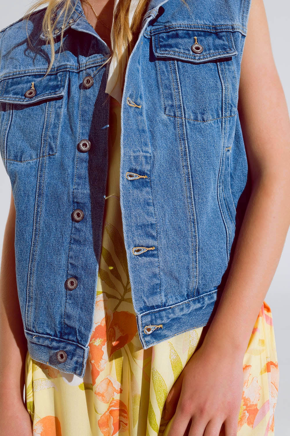 Light wash denim vest with rhinestone detail on the collar