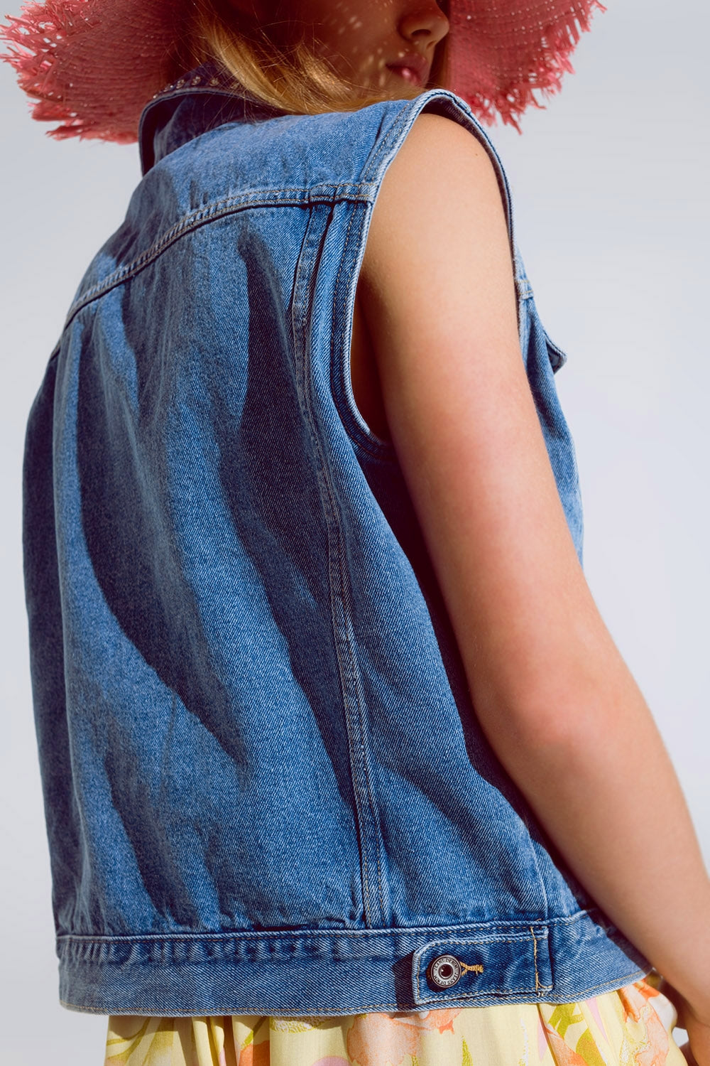 Light wash denim vest with rhinestone detail on the collar