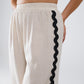 Pantalones de lino con ribete festoneado en contraste en color beige