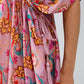 Vestido largo en color rosa con costuras trenzadas y estampado de flores