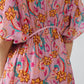 Vestido largo en color rosa con costuras trenzadas y estampado de flores