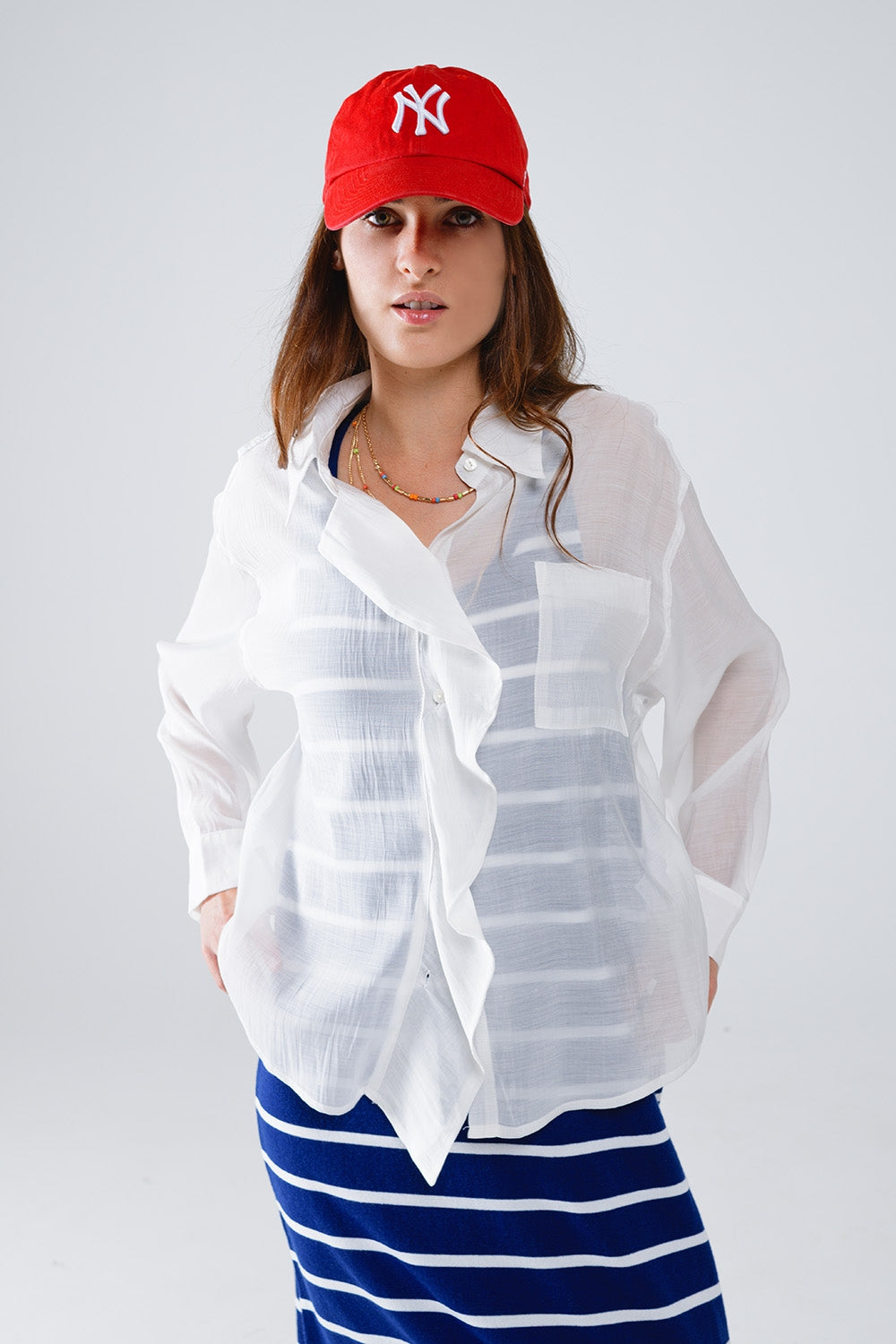 Blusa blanca semitransparente con detalle de volantes en la parte delantera