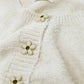 Short and fluffy cream cardigan with flower buttons