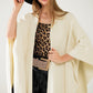 Soft knitted poncho in beige with fringes