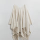 Soft knitted poncho in beige with fringes