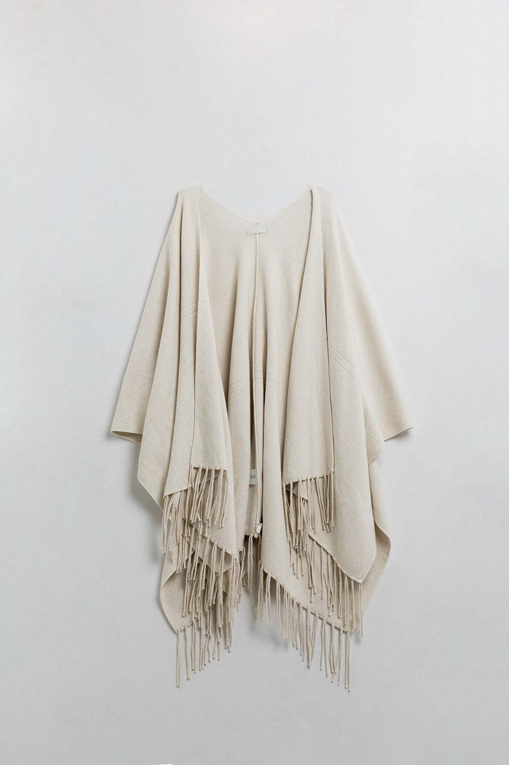 Soft knitted poncho in beige with fringes