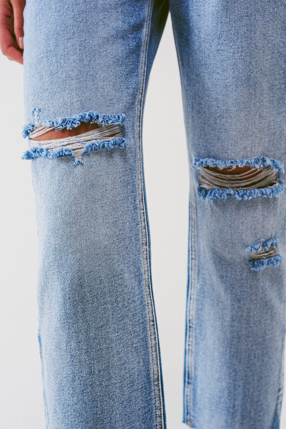 Sraight-leg jeans with exposed buttons and ripped knees in light wash