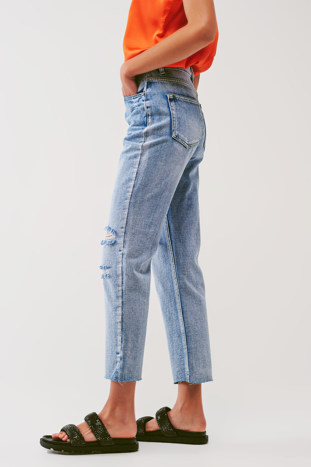 Sraight-leg jeans with exposed buttons and ripped knees in light wash