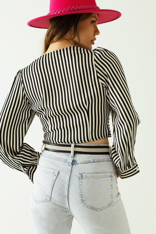 Striped crop top with V-neckline and twisted front in black and white.