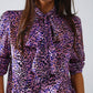 Blusa morada con estampado animal y lazo en el cuello