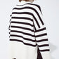 White oversized trutleneck sweater with black stripes and splits on the side