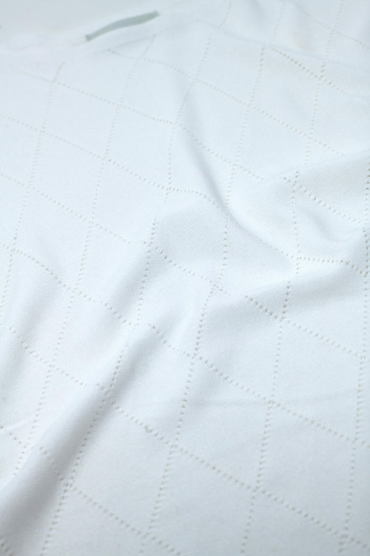 Suéter blanco con estampado de rombos y cuello barco