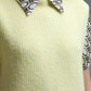 Yellow sleeveless sweater with gold buttons on side