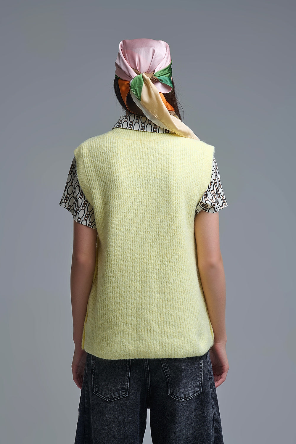 Yellow sleeveless sweater with gold buttons on side