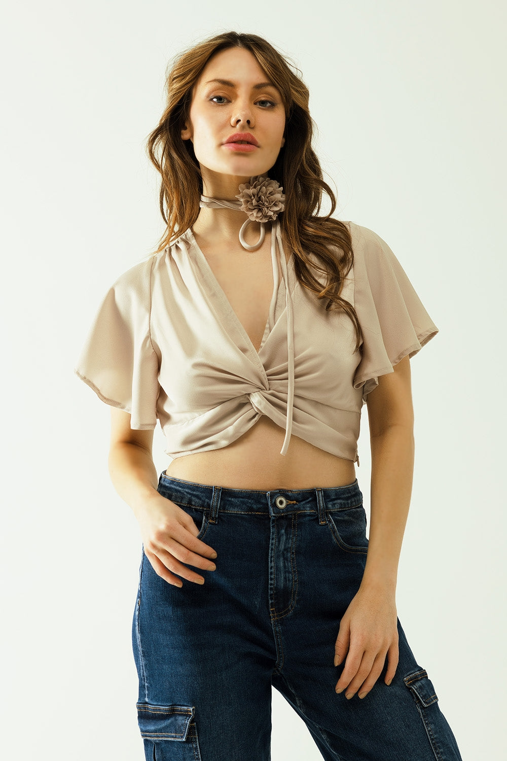Q2 Beige V-neck crop top with short sleeves and a flower detail on the neck