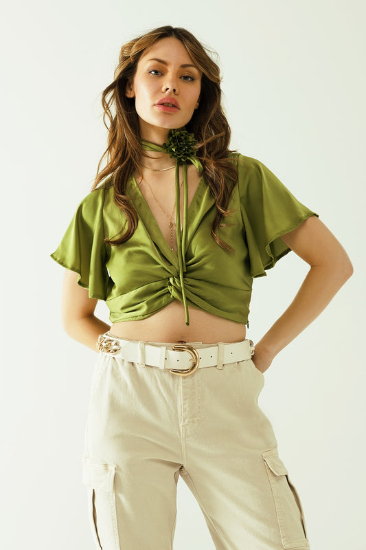 Q2 Green V-neck crop top with short sleeves and a flower detail on the neck