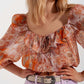 Long sleeve sheer top with shirred waist and tie detail in orange Szua Store
