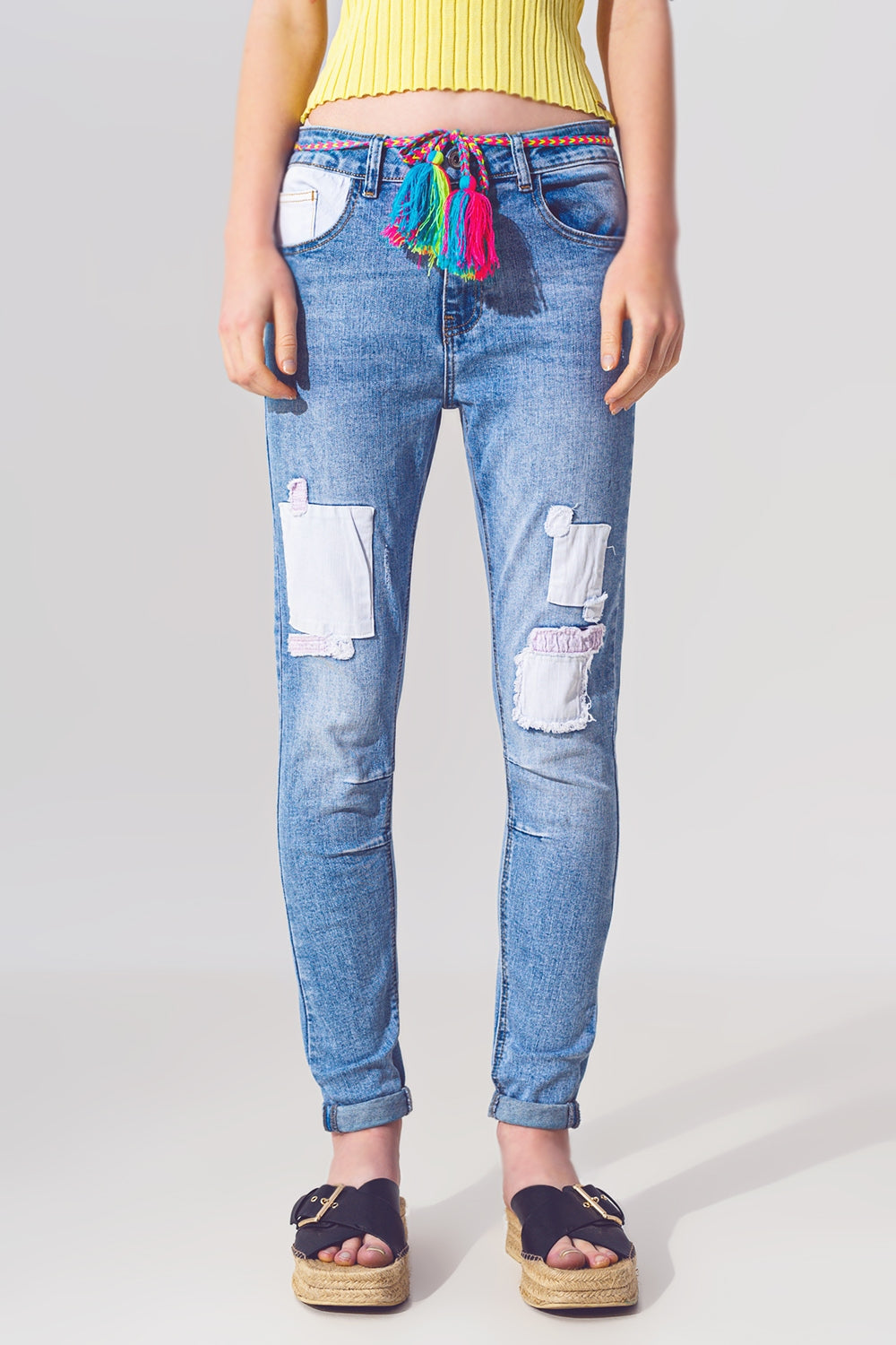 Jeans ajustados elásticos con parches en lavado medio y detalle de cinturón