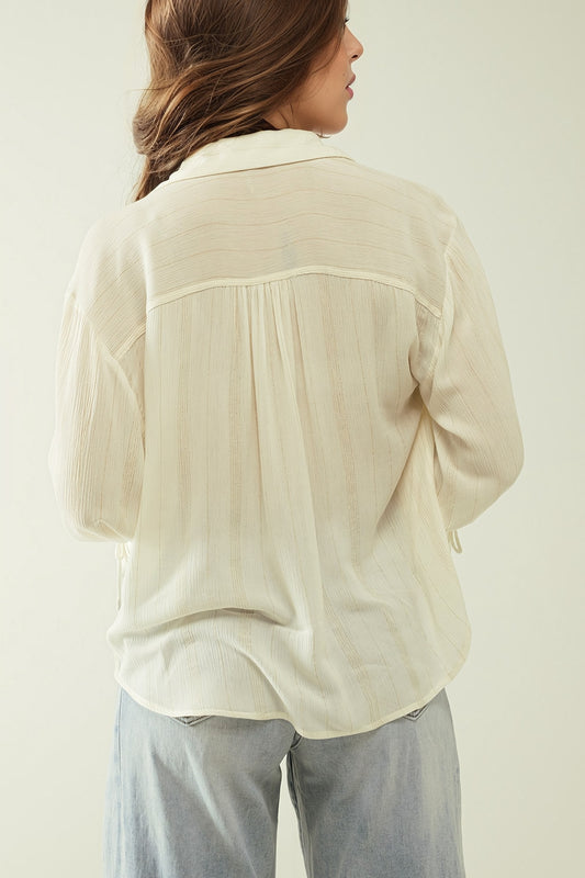 Camisa blanca clara con cuello de pico y detalles de rayas