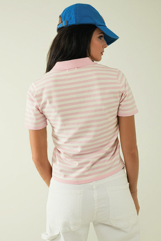 Polo blanco de manga corta con rayas rosa claro y detalle de botones frontales.