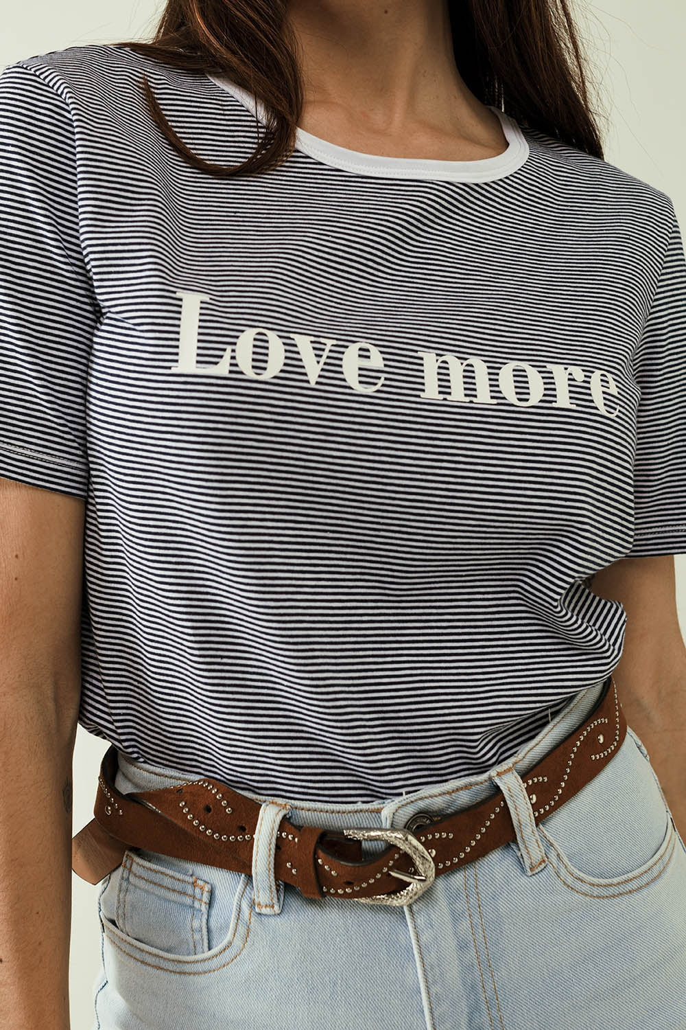 Camiseta blanca con rayas negras y texto Love More